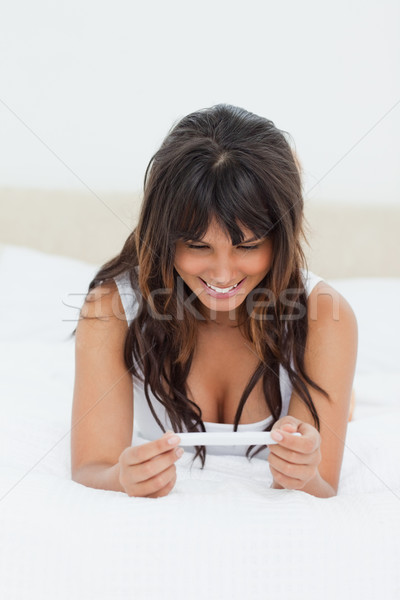 Feliz mulher jovem teste de gravidez cama branco Foto stock © wavebreak_media