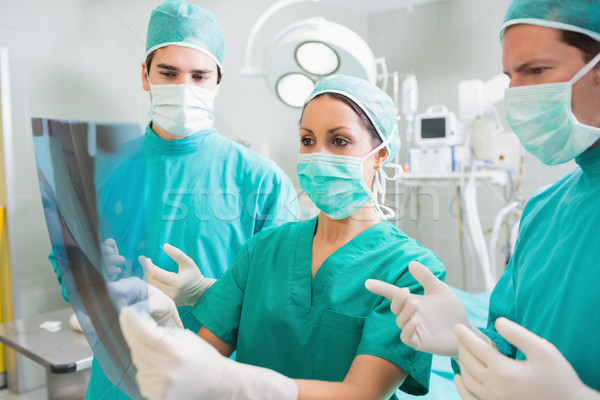 Surgical team examining a X-ray in an operating theatre Stock photo © wavebreak_media