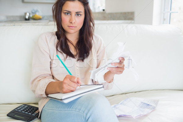 Young woman looking stressed over bills on sofa Stock photo © wavebreak_media
