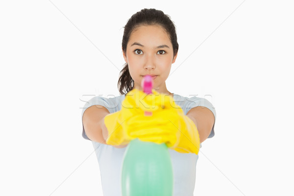 Woman pointing a spray bottle at the camera on a white background Stock photo © wavebreak_media
