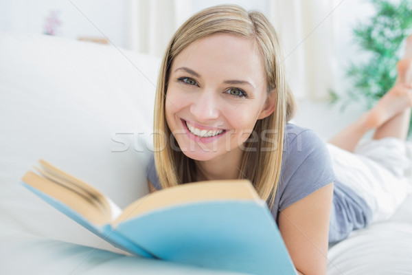 Portrait of happy woman with storybook lying on couch Stock photo © wavebreak_media