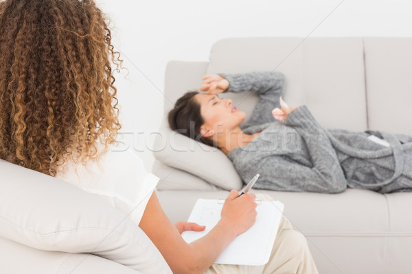 Therapist writing notes on her crying patient on the couch Stock photo © wavebreak_media