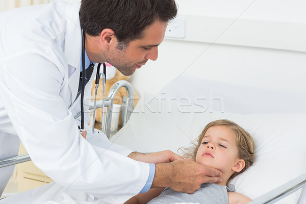 Doctor checking thyroid glands of sick girl Stock photo © wavebreak_media