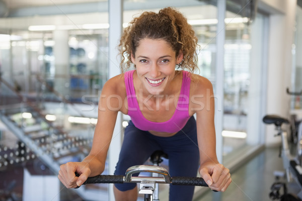 Pretty fit woman on the spin bike smiling at camera Stock photo © wavebreak_media