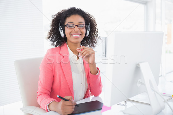 Casual graphic designer working at her desk smiling at camera Stock photo © wavebreak_media