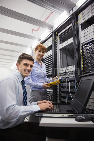 Team of technicians using digital cable analyser on servers Stock photo © wavebreak_media