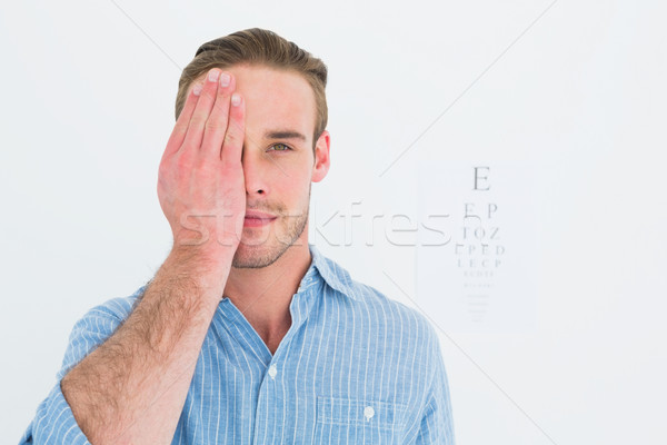 Unsmiling patient looking at camera with one eye Stock photo © wavebreak_media