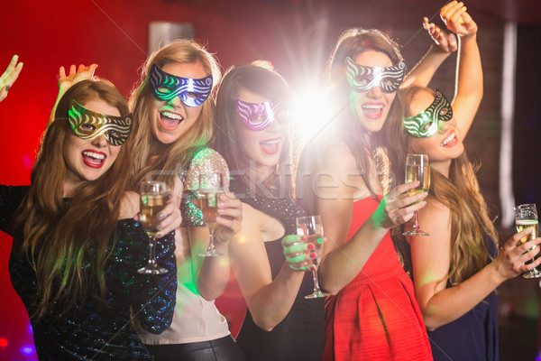 Stock photo: Friends in masquerade masks drinking champagne