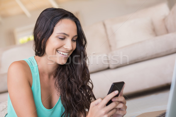 Pretty brunette texting with her smartphone  Stock photo © wavebreak_media
