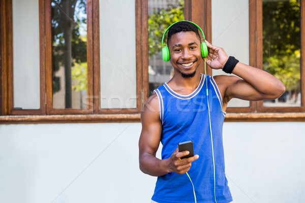 Przystojny sportowiec słuchanie muzyki zdrowia słuchawki Zdjęcia stock © wavebreak_media