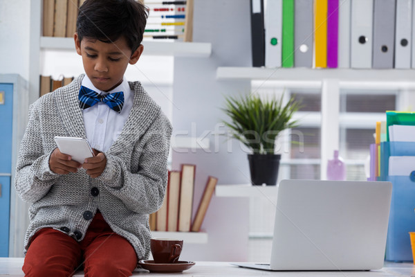 Businessman using smartphone while sitting on desk Stock photo © wavebreak_media