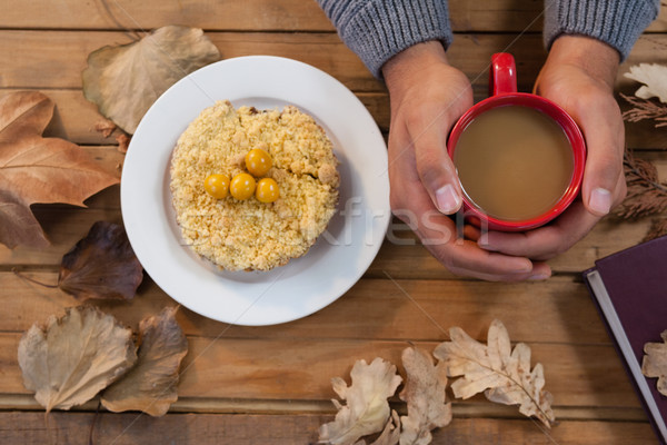 Hand of man holding cup of coffee with breakfast and autumn leaves on table Stock photo © wavebreak_media