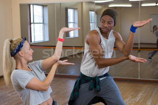 Friends rehearsing dance against mirror on wooden floor Stock photo © wavebreak_media
