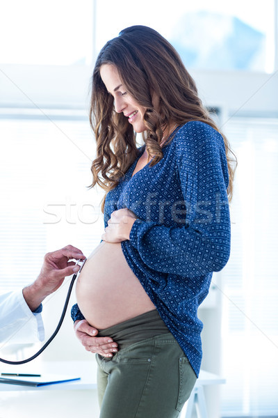 Stock photo: Cropped image of doctor examining pregnant woman belly in clinic