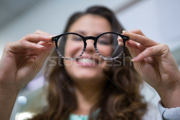Female customer holding spectacles in optical store Stock photo © wavebreak_media