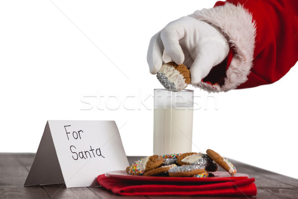 Close-up of santa claus dipping cookies in a glass of milk Stock photo © wavebreak_media