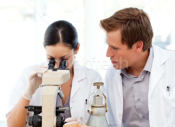 Scientists looking through a microscope Stock photo © wavebreak_media