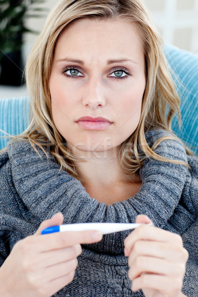 Jonge vrouw thermometer naar camera sofa vrouwelijke Stockfoto © wavebreak_media
