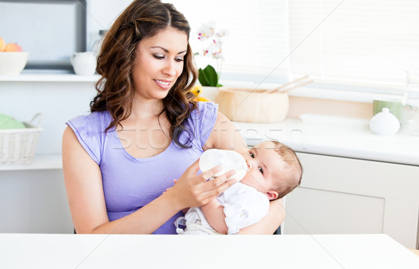 Cute mother feeding her baby siiting in the kitchen at home Stock photo © wavebreak_media