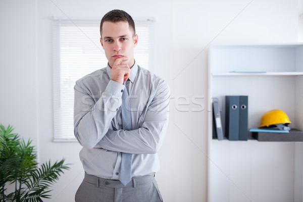 Stock photo: Businessman thinking and standing in his office