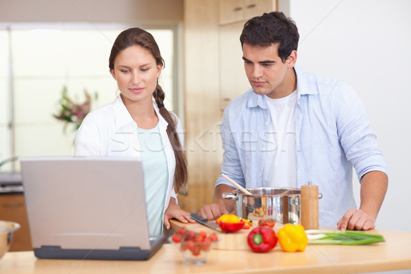 Couple utilisant un ordinateur portable Cook cuisine alimentaire heureux Photo stock © wavebreak_media