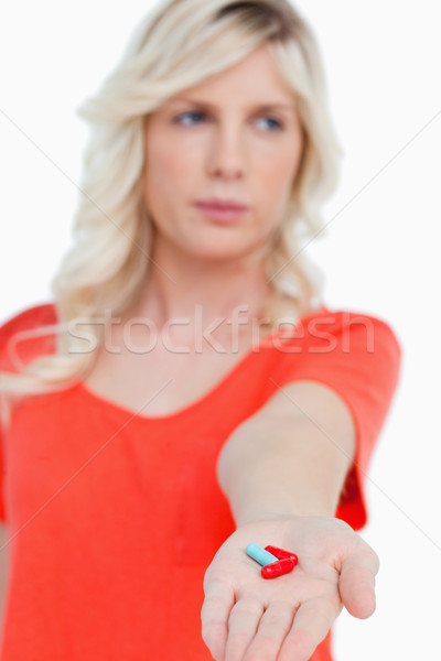 Red and blue vitamins held by a young woman against a white background Stock photo © wavebreak_media