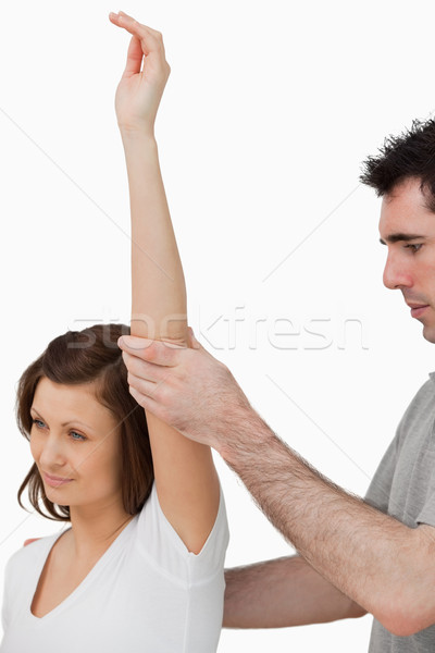 Serious doctor raising the arm of a woman in a room Stock photo © wavebreak_media