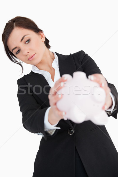 Woman in black suit emptying a piggy bank against white background Stock photo © wavebreak_media