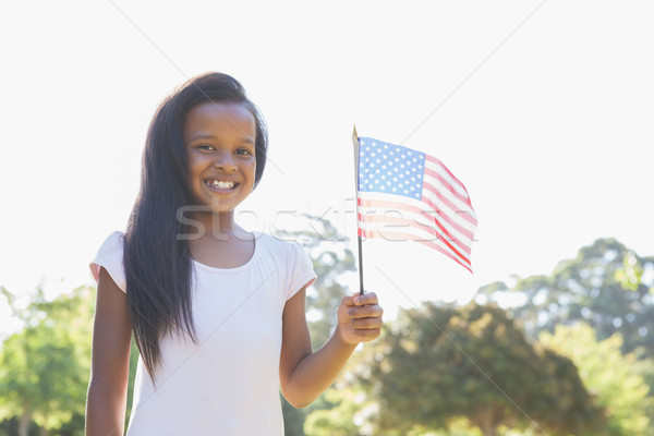 Little girl smiling at camera waving american flag Stock photo © wavebreak_media