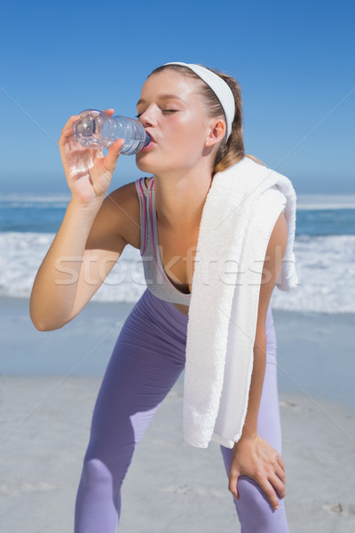 Sporty tired blonde drinking water on the beach Stock photo © wavebreak_media