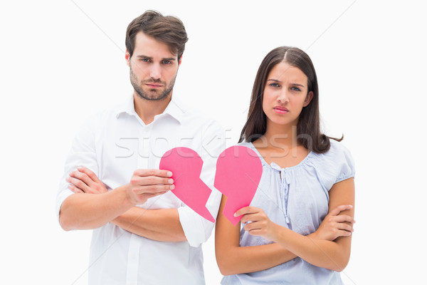 Upset couple holding two halves of broken heart Stock photo © wavebreak_media