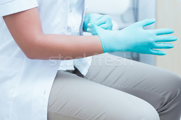 Stock photo: Mid section of dentist wearing surgical glove