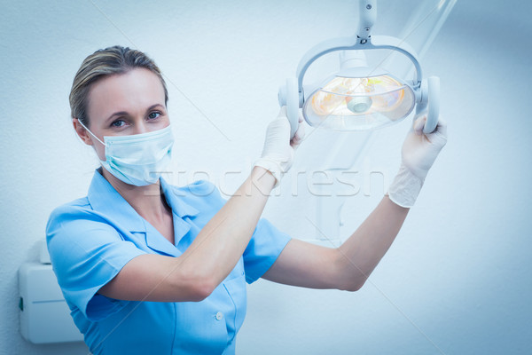 Female dentist in surgical mask adjusting light Stock photo © wavebreak_media