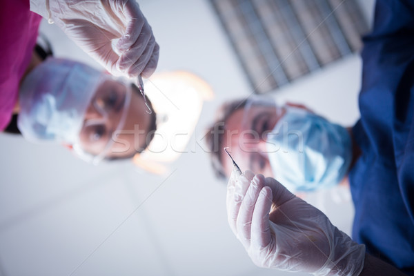 Dentist and assistant leaning over patient with tools Stock photo © wavebreak_media