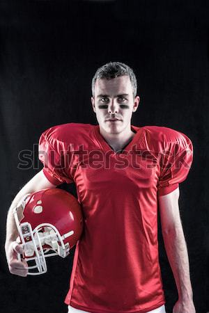 American football player holding a helmet against blue background Stock photo © wavebreak_media