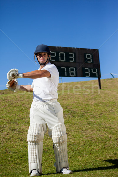 Cricket player swinging bat while standing at field Stock photo © wavebreak_media