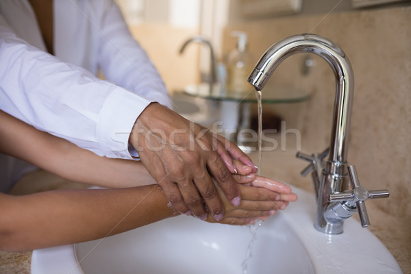 Mid section of granny helping girl while washing hands at sink Stock photo © wavebreak_media