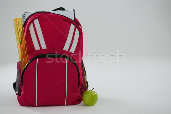 Schoolbag with various supplies and apple on white background Stock photo © wavebreak_media