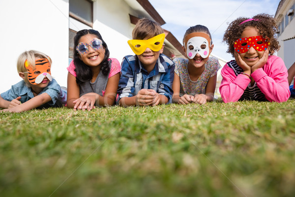 Portrait of children wearing masks lying on field Stock photo © wavebreak_media