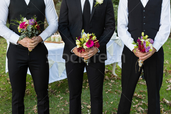 Bridegroom and best man standing with bouquet of flowers in garden Stock photo © wavebreak_media