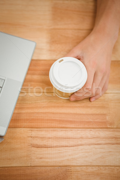 Man holding disposable cup on table in office Stock photo © wavebreak_media