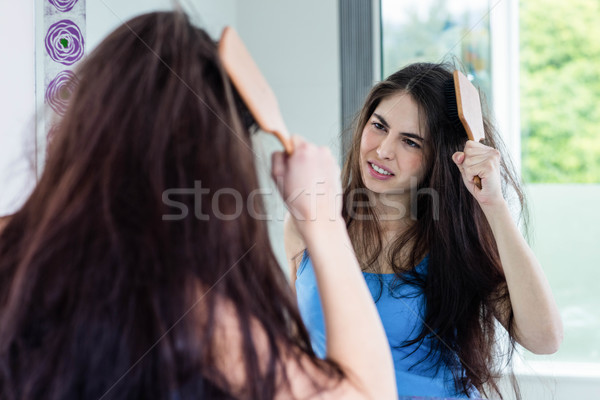 Unsmiling brunette combing Stock photo © wavebreak_media