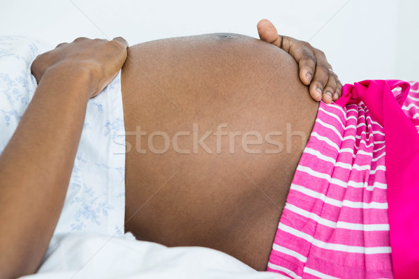 Kobieta dotknąć brzuch relaks bed Zdjęcia stock © wavebreak_media