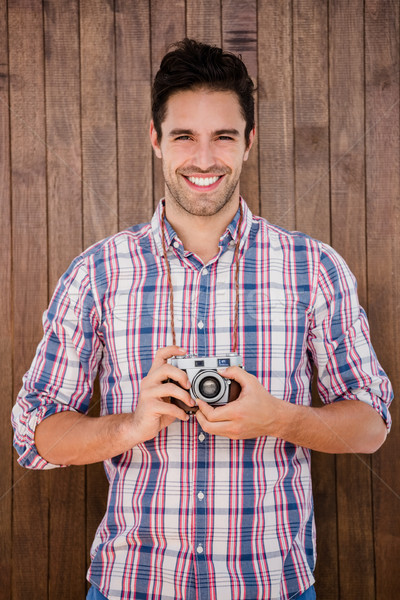 Portrait of young man standing with a digital camera Stock photo © wavebreak_media
