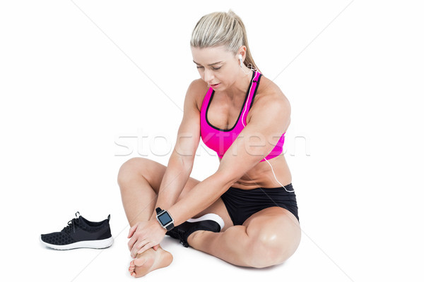 Injured female athlete sitting and touching ankle Stock photo © wavebreak_media