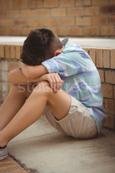 Sad schoolboy sitting alone on steps in campus Stock photo © wavebreak_media