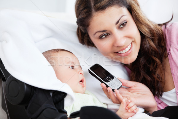 Smiling young mother showing a cellophone to her curious baby Stock photo © wavebreak_media