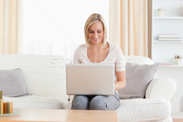 Wwoman using a laptop while sitting on a sofa Stock photo © wavebreak_media