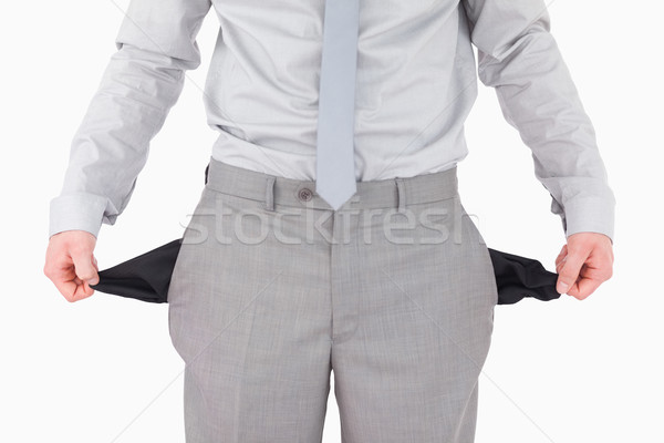 Stock photo: Businessman showing his empty pockets against a white background