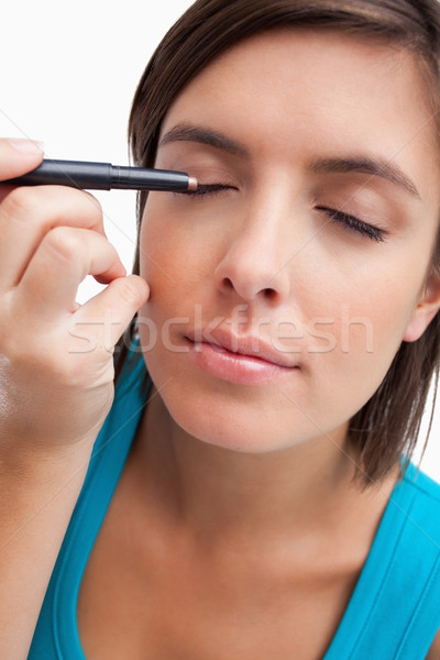 Young beautiful female using an eye pencil to apply make-up Stock photo © wavebreak_media